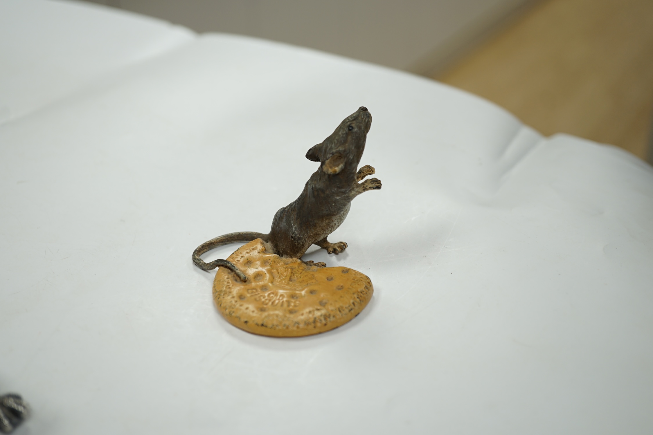 Franz Bergmann (1861-1936), a cold painted bronze study of a mouse and a biscuit, stamped marks to base, 5cm tall. Condition - fair